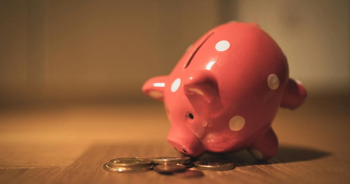 A savings account statement beside cash and rising price tags, illustrating the hidden cost of cash over time