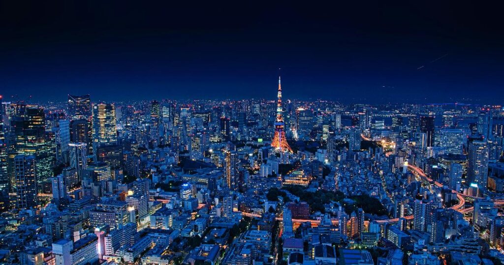 A Tokyo skyline with the yen exchange rate board and stock market screens, illustrating Japan rate hike risks for investors.