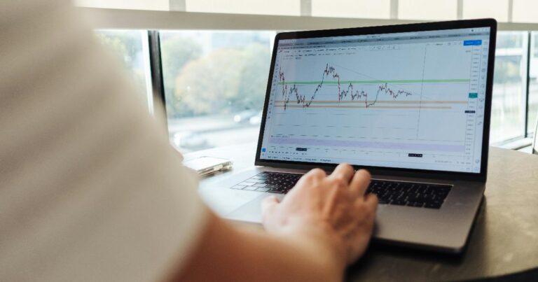A financial analyst reviewing stock charts and market forecasts, illustrating the limits of the market forecasting lesson from 2016